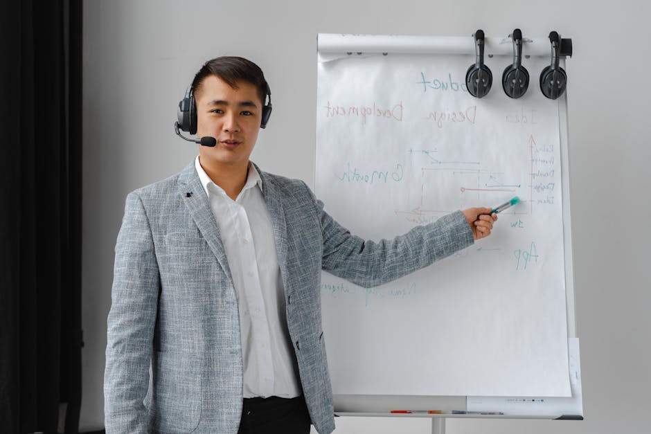 Asian man conducting a business presentation with a headset and flipchart.