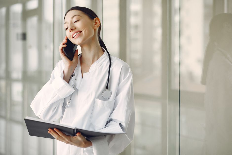 Liječnica razgovara na telefonu u bolničkom hodniku